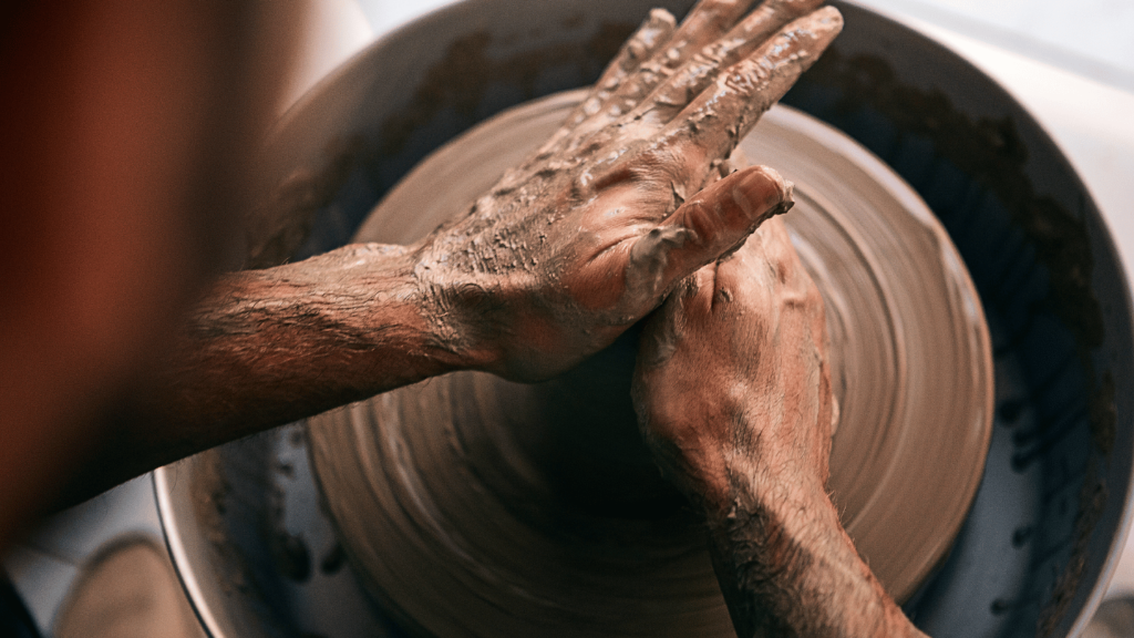 Person shaping clay on a pottery wheel