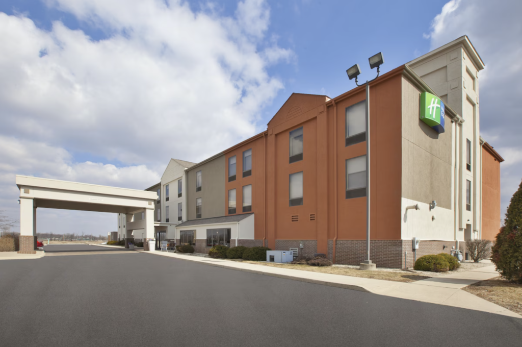 Exterior photo of the parking lot and entrance of the Holiday Inn Express Tiffin